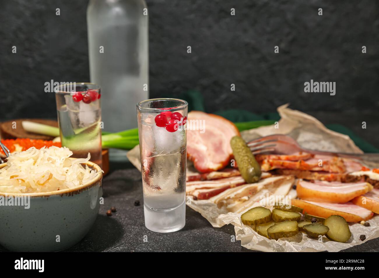 Shots with cold vodka and snacks on black background Stock Photo - Alamy