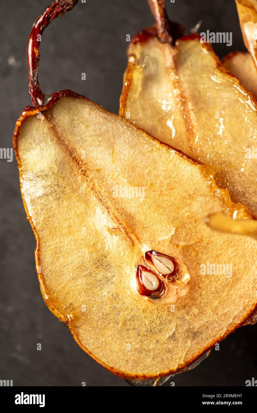 Candied pear chips, first dehydrated and then dipped in a caramel sugar solution and left to dry. Stock Photo