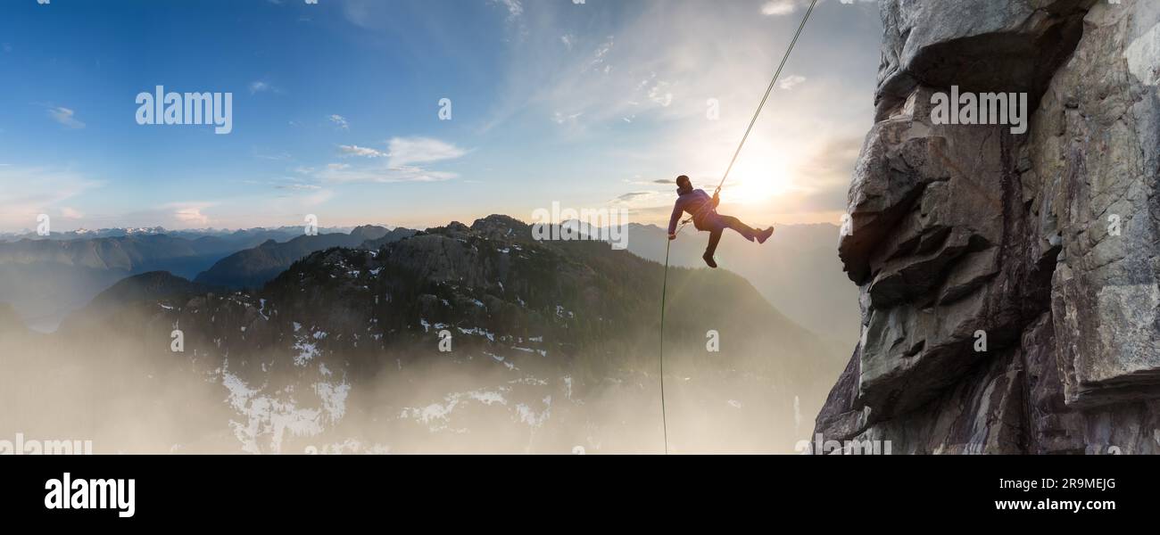 Adventure Man on rope Rappelling down a mountain cliff. Extreme Sport