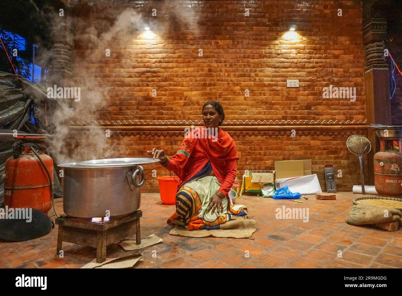 Kusmawat Harijan cooks rice to prepare dinner in Kathmandu, Bagmati province, Nepal on May 16, 2023. (Sunita Neupane/Global Press Journal) Stock Photo
