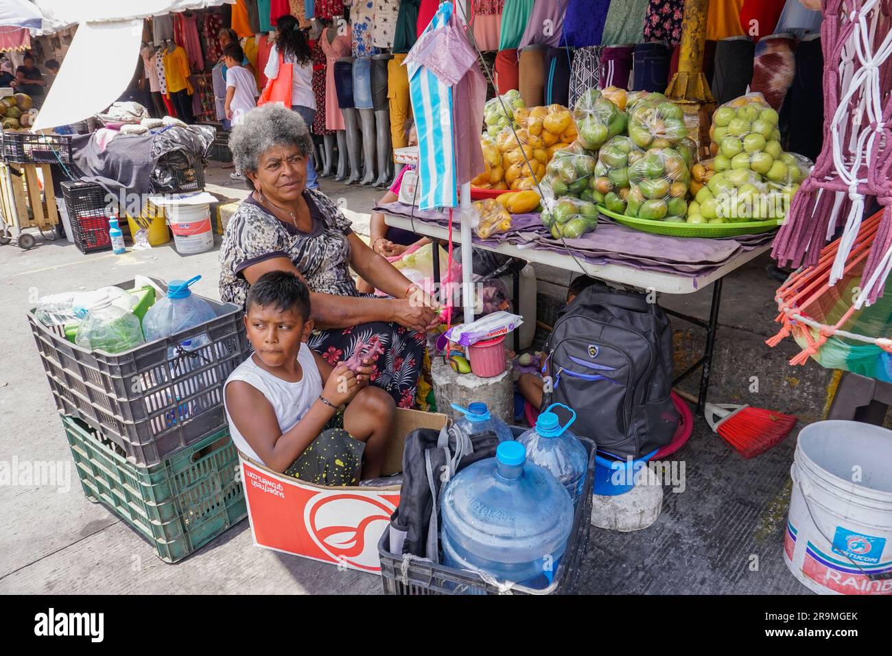 María Baños takes care of her grandson, Hashyar Zamora Ávila, 8, at her fruit stand in Chilpancingo de los Bravo, Guerrero, Mexico on April 23, 2023, while her daughter works. (Avigaí Silva/Global Press Journal) Stock Photo