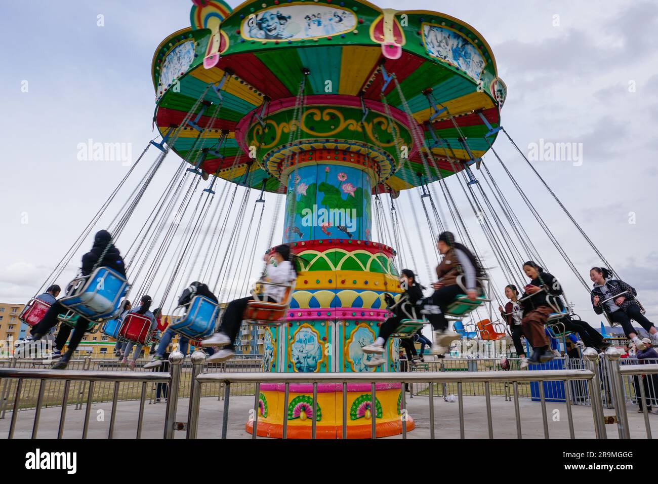 Classmates ride a merry-go-round swing at a newly opened children’s park in Murun soum, Khuvsgul province, Mongolia on May 20, 2023. (Dolgormaa Sandagdorj/Global Press Journal) Stock Photo