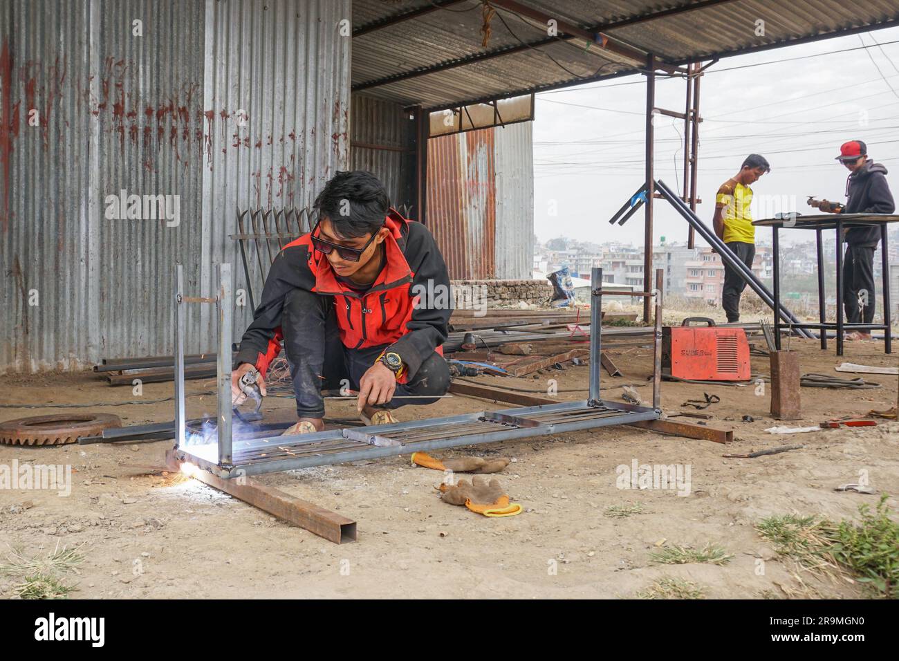 Santosh Tamang welds at a workshop in Kathmandu, Bagmati province, Nepal on Jan. 30, 2023. (Sunita Neupane/Global Press Journal) Stock Photo