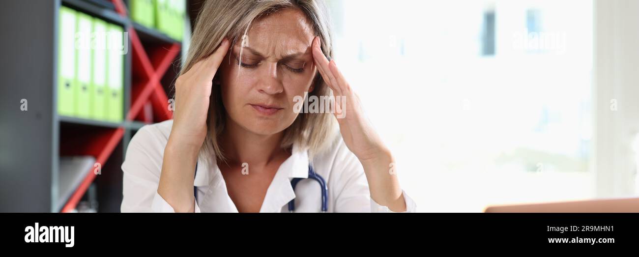 Frustrated doctor touching temples and closed eyes Stock Photo
