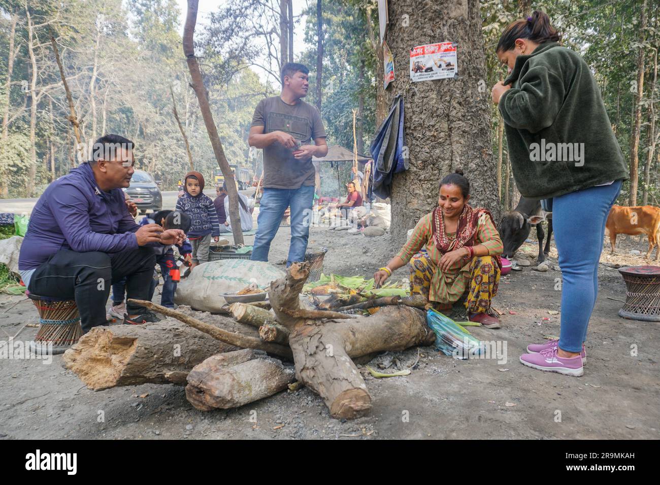 Anjana Basnet, sitting on the right, sells grilled corn along the East-West Highway in Belbari, Morang, Nepal on Jan. 26, 2023. (Maya Neupane/Global Press Journal) Stock Photo