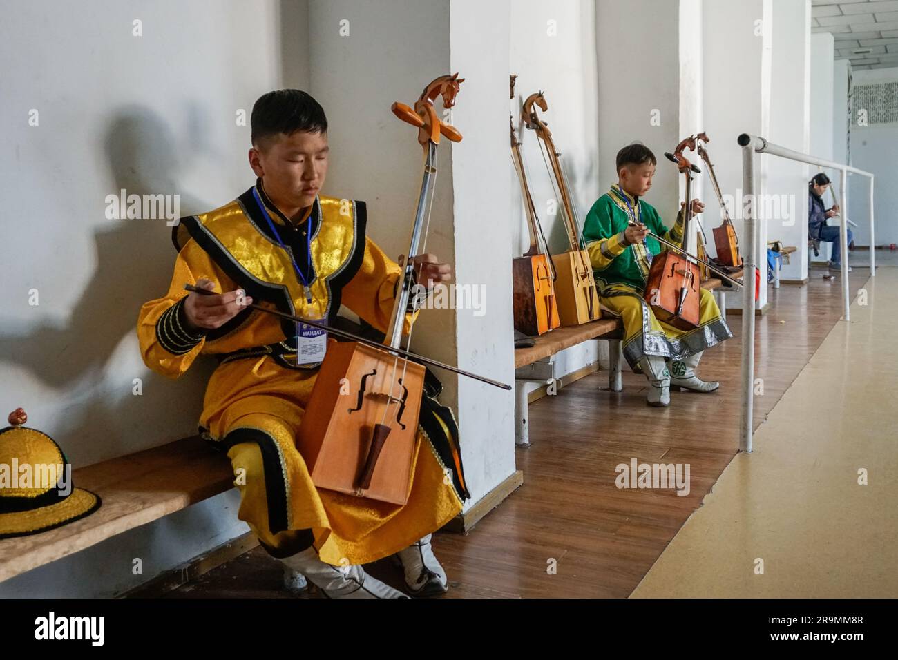 Bayanmunkh Odgarig, left, 14, and Shinekhuu Sukhbaatar, 14, rehearse morin khuur, or horsehead fiddle, backstage at a festival in Dalanzadgad, Umnugovi province, Mongolia on April 29, 2023. (Uranchimeg Tsoghuu/Global Press Journal) Stock Photo