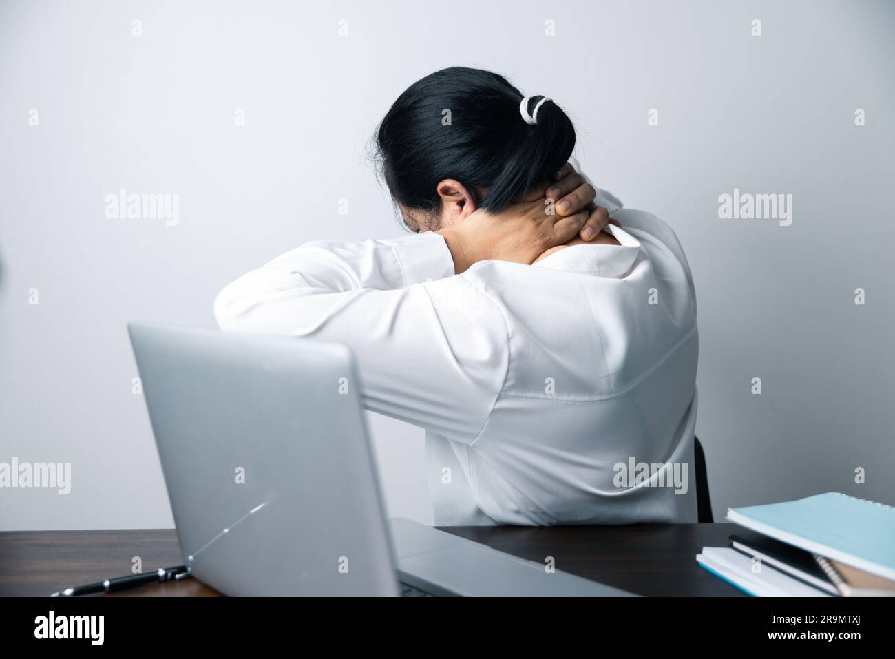 A business office worker is an asian woman is sitting in front of the ...