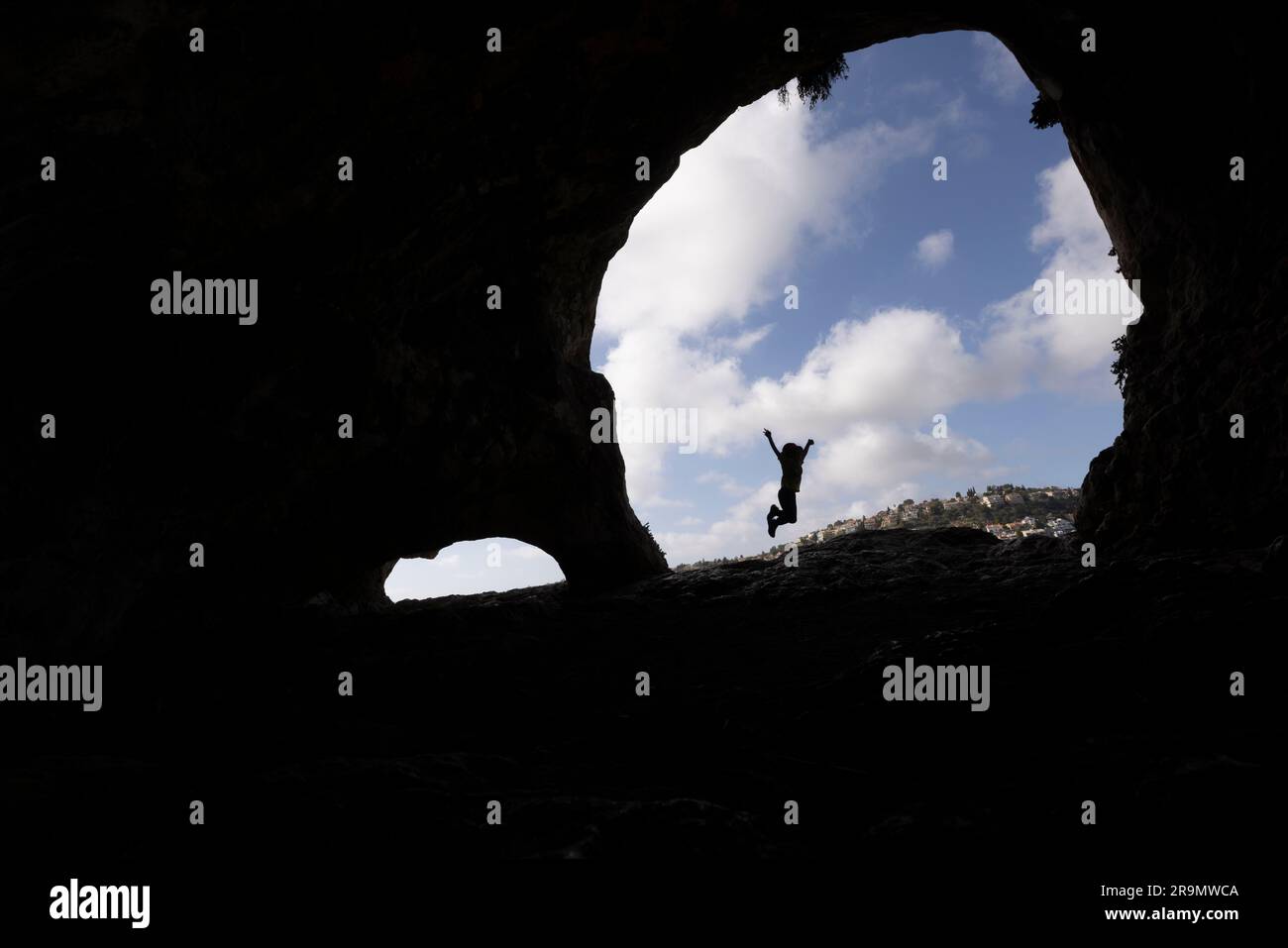 Silhouette of an excited hiker jumping with joy on reaching his destination Stock Photo