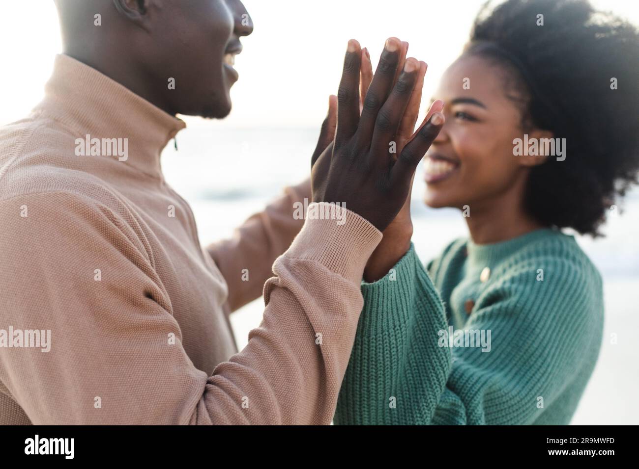 Happy african american couple holding hands and smiling on beach Stock ...