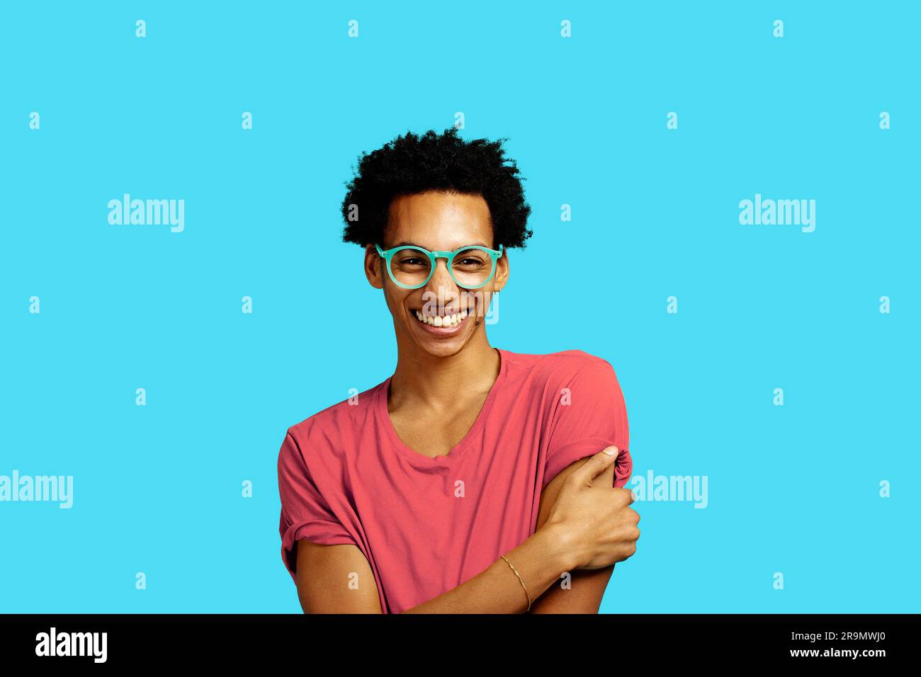 happy young man wearing glasses smiling isolated on blue background Stock Photo