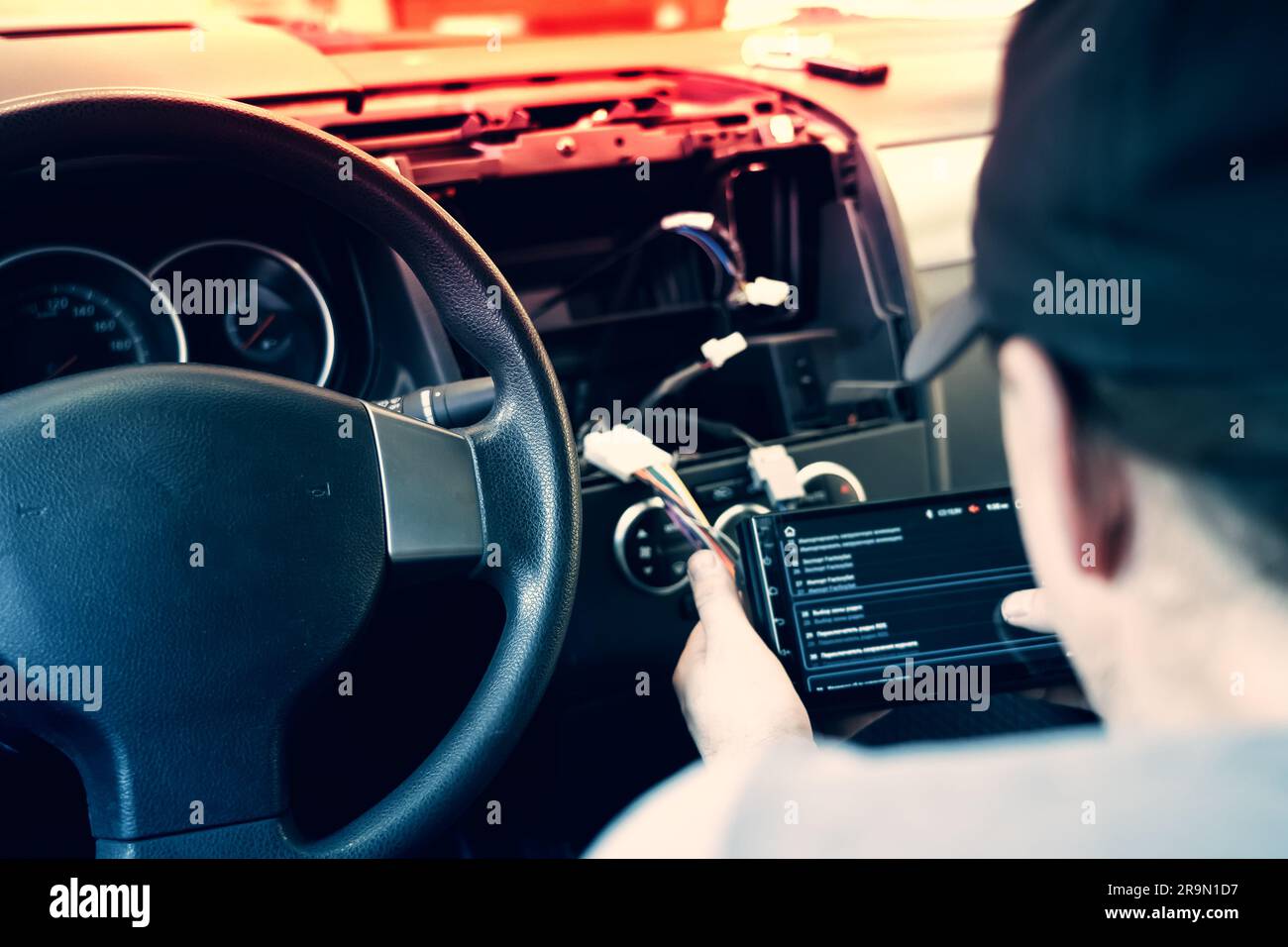 Auto in Car Service, process of installing modern 2-din radio sound system. Auto electric hands on dashboard fixing problem close-up. Stock Photo