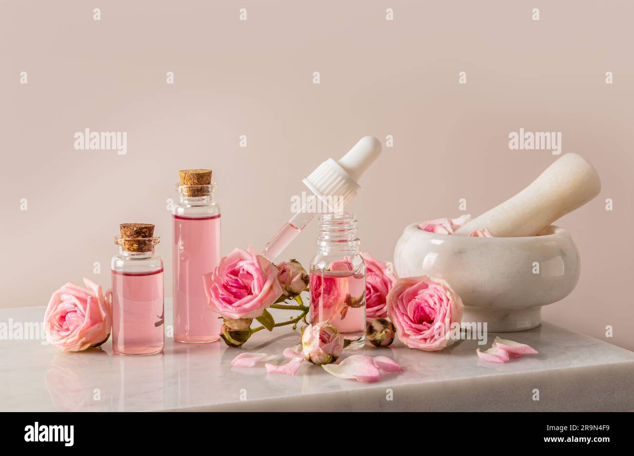 A set of cosmetics based on rose oil in various bottles among the buds ...