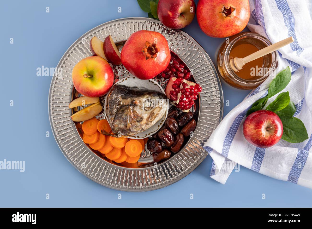 A silver dish with traditional food Rosh Hashanah. pomegranates, apples