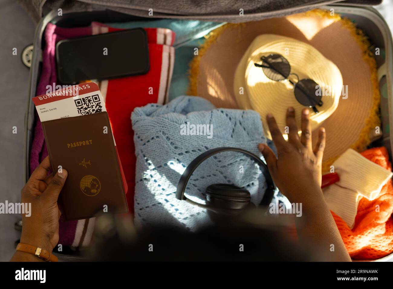 Hands of plus size african american woman packing suitcase Stock Photo