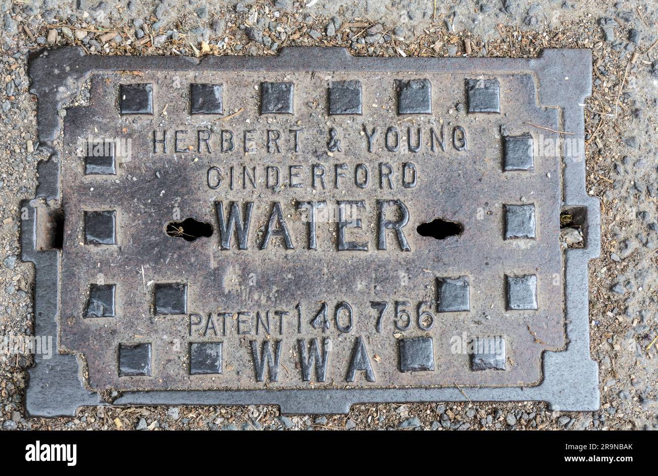 Water mains iron cover in road. England, UK. Stock Photo