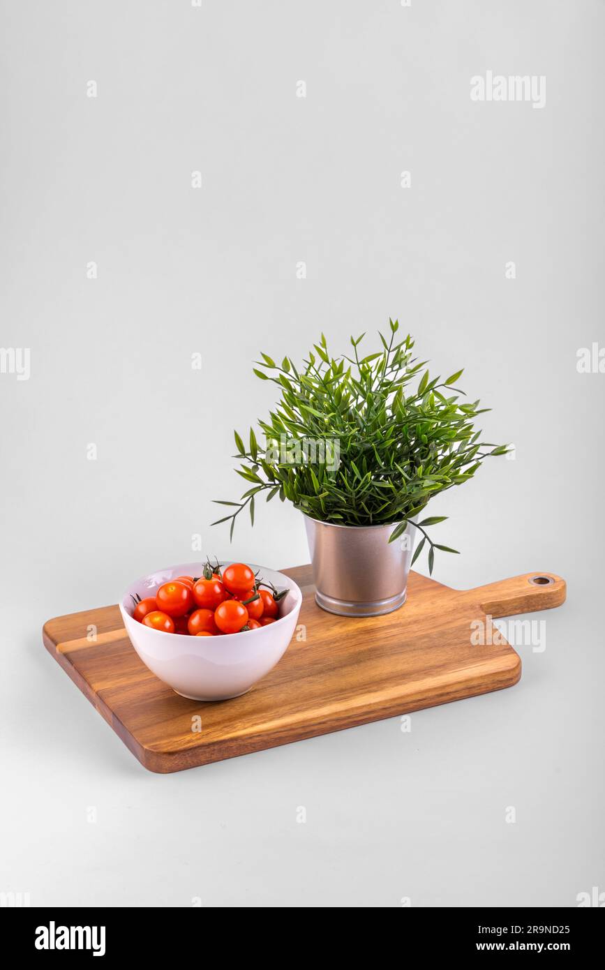 Red fresh Cherry Tomatoes on chopping boards and in a withe bowl Stock Photo