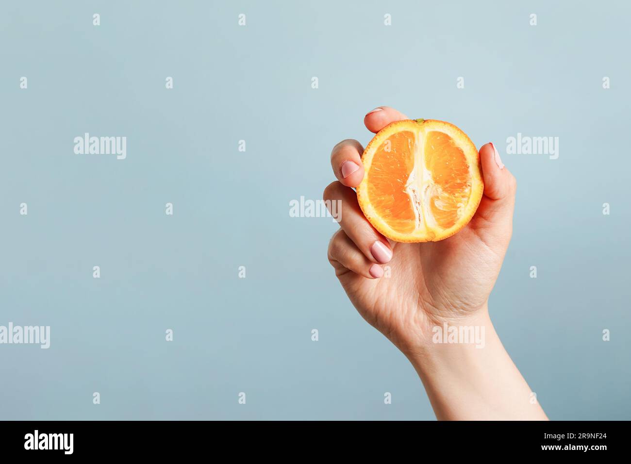 Hand holding half orange hi-res stock photography and images - Alamy