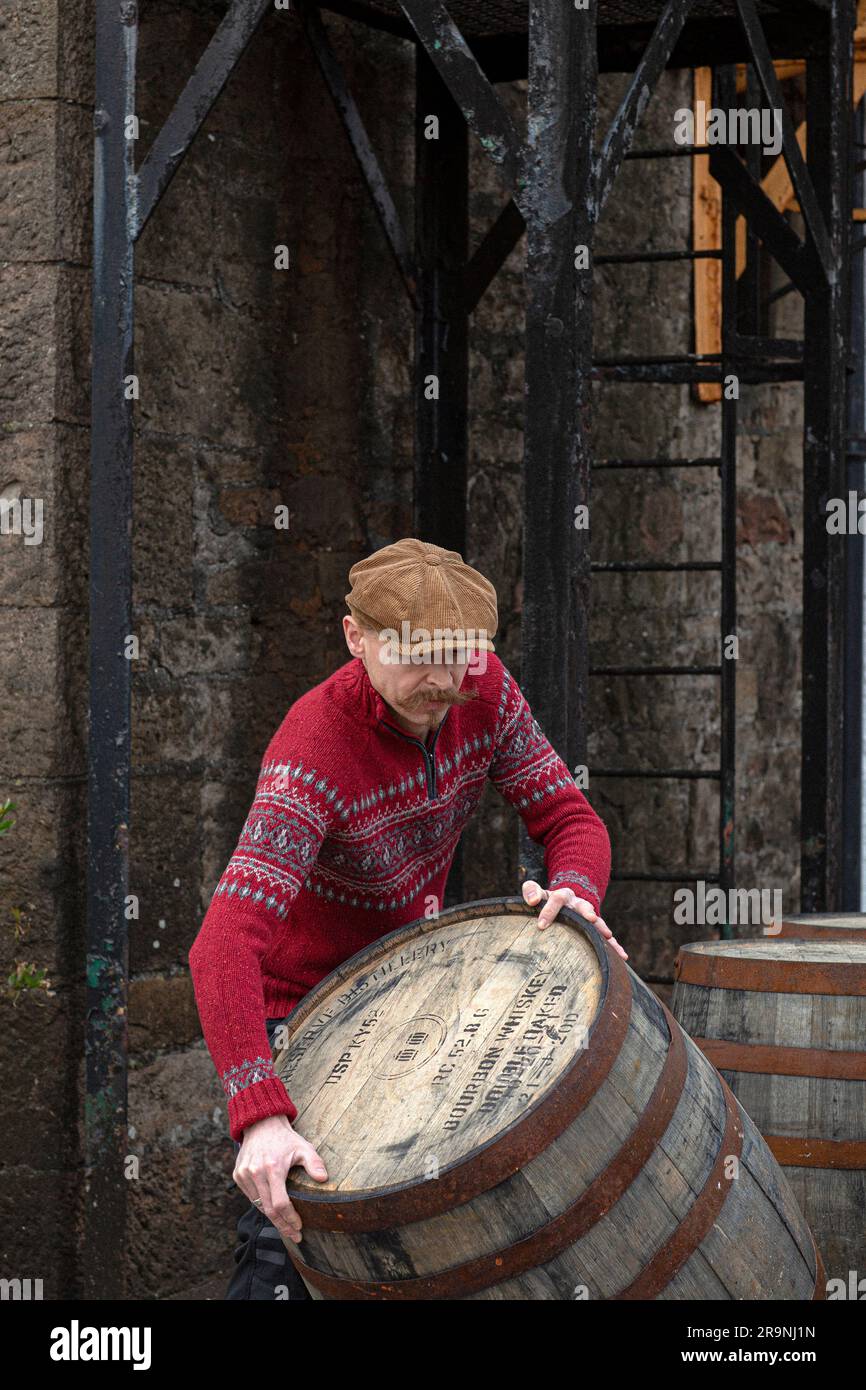 Worker rolling whisky cask in whisky distillery , Scotland. Stock Photo