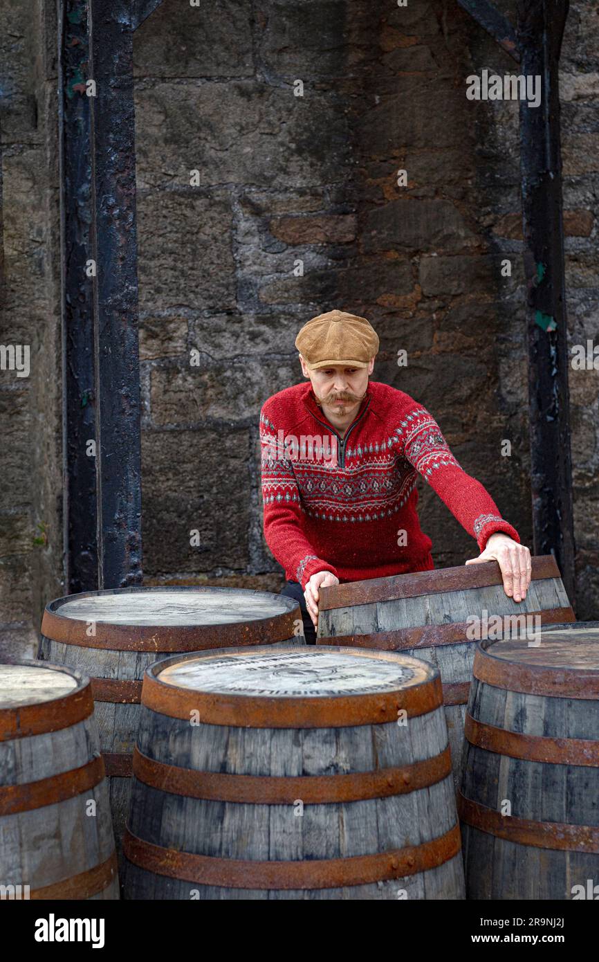 Worker rolling whisky cask in whisky distillery , Scotland. Stock Photo