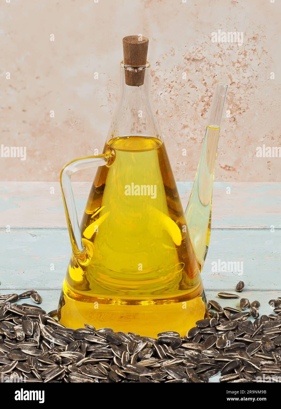 A jug of cold pressed sunflower oil on bright blue wooden background Stock Photo