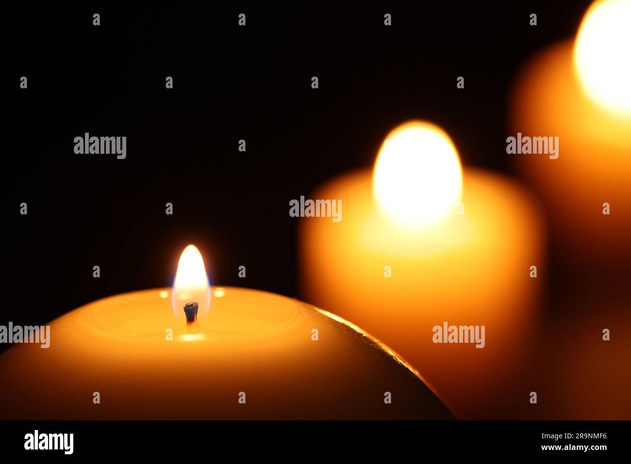 Burning wax candles on black background, closeup. Space for text Stock ...