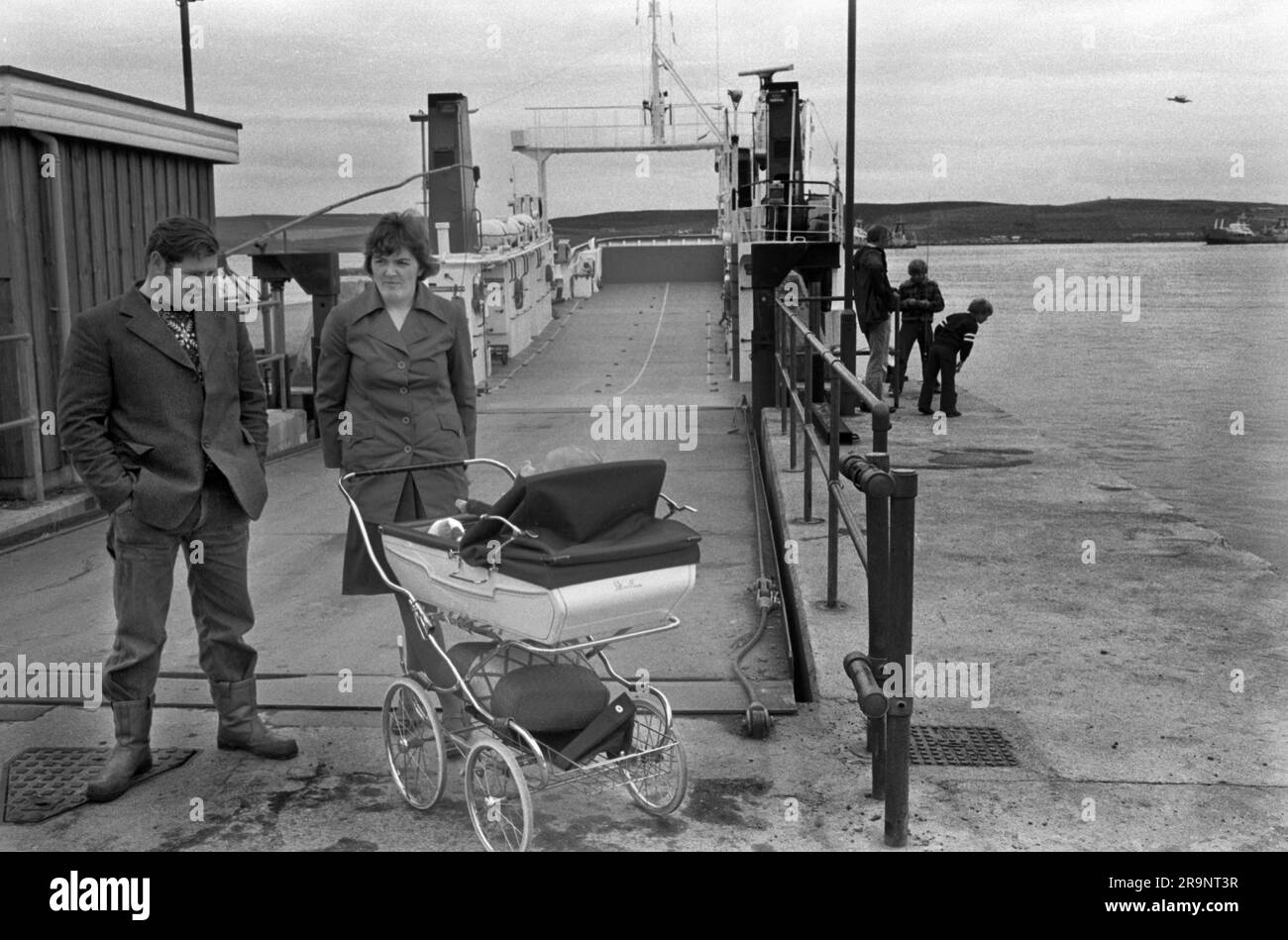 Couple with baby in pram, waiting for the roll on roll off ferry to Bressay. Lerwick, Shetlands Mainland, Shetland Islands, Scotland, circa 1979. UK 1970S HOMER SYKES Stock Photo