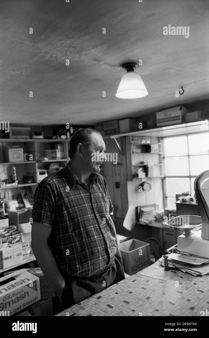 Shetlands daily life 1970s. A shop keeper behind the counter of his genera store. Shetlands Mainland, Shetland Islands, Scotland 1979. 70s HOMER SYKES Stock Photo