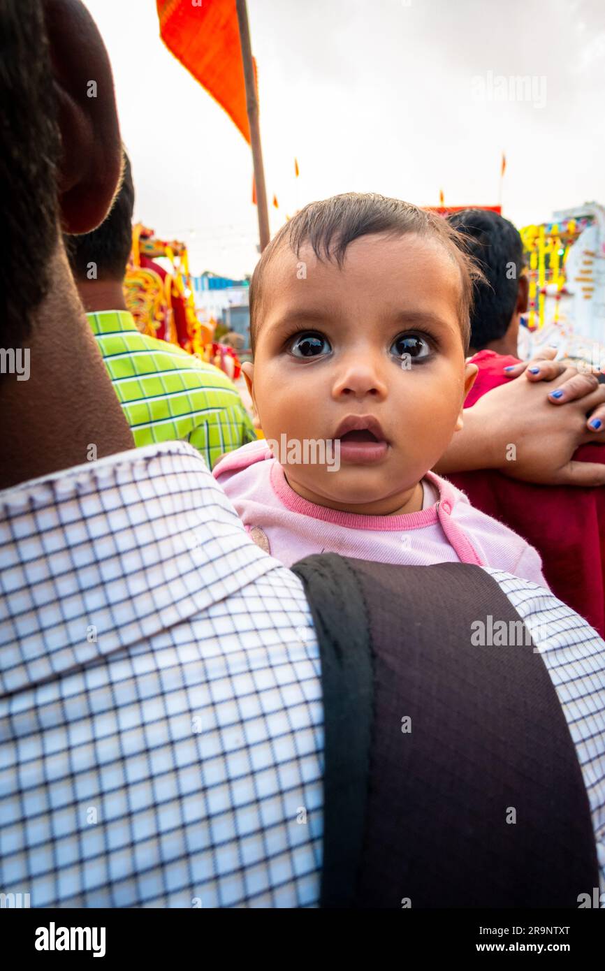 October 19th 2022, Dehradun, Uttarakhand, India. A cute Indian kid watcher over its father's shoulder on the streets. Stock Photo