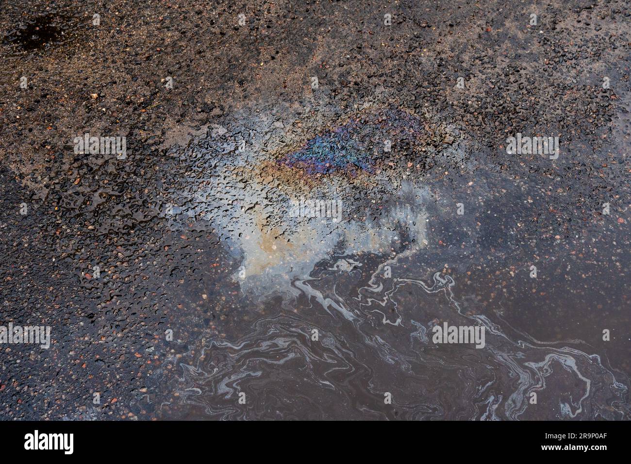 Oil stains from leaks in the car engine. Oil after rain makes spots