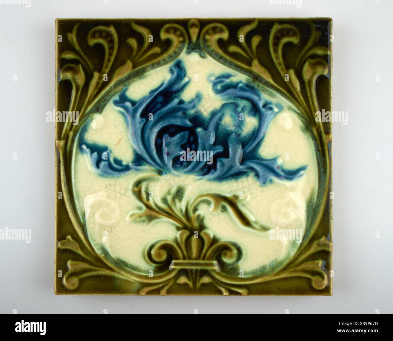 Antique 1900s Corn Bros Art Nouveau blue frilly poppy pottery tile Stock Photo