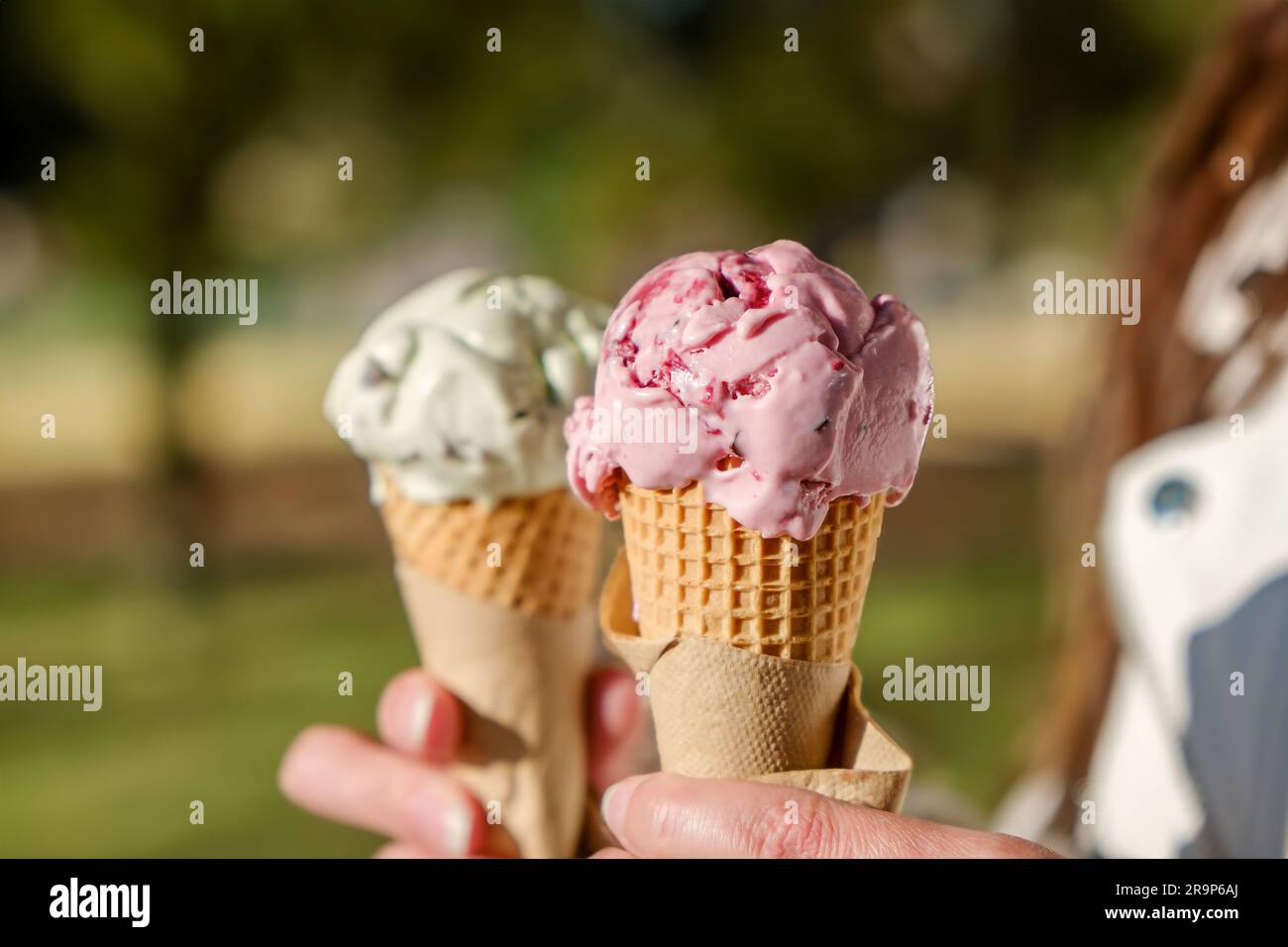 Two scoops of ice cream in hand. ice cream on a summer day outdoors
