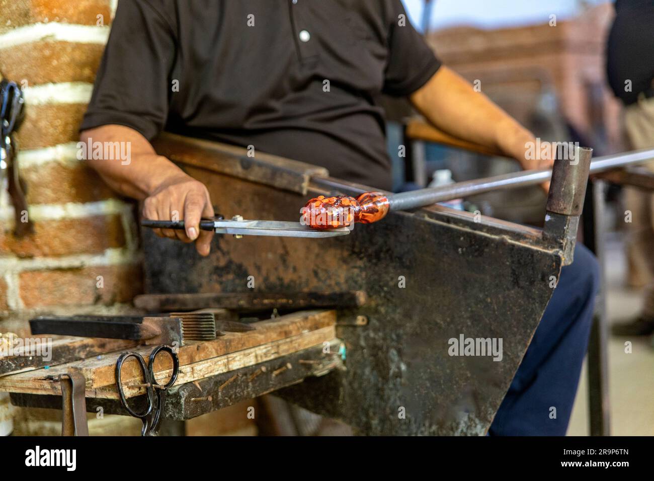 Craftsman working, cutting and molding the glass with the traditional