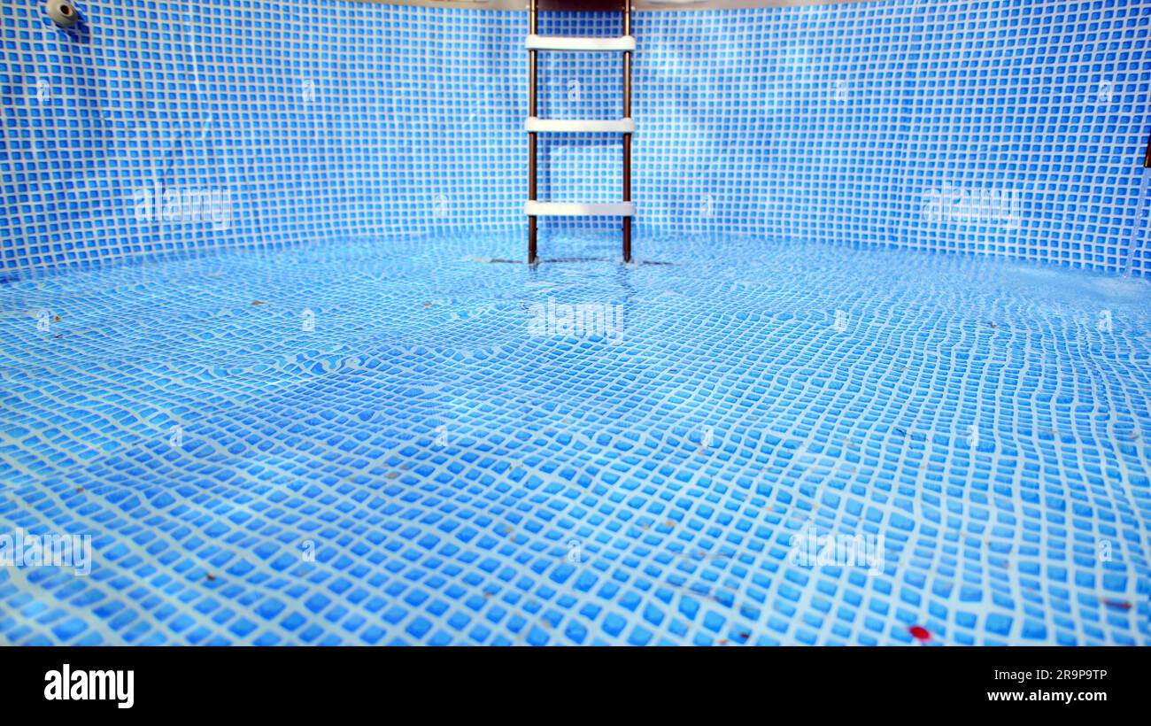 Water flowing from the hose into the pool filling. The inside of the