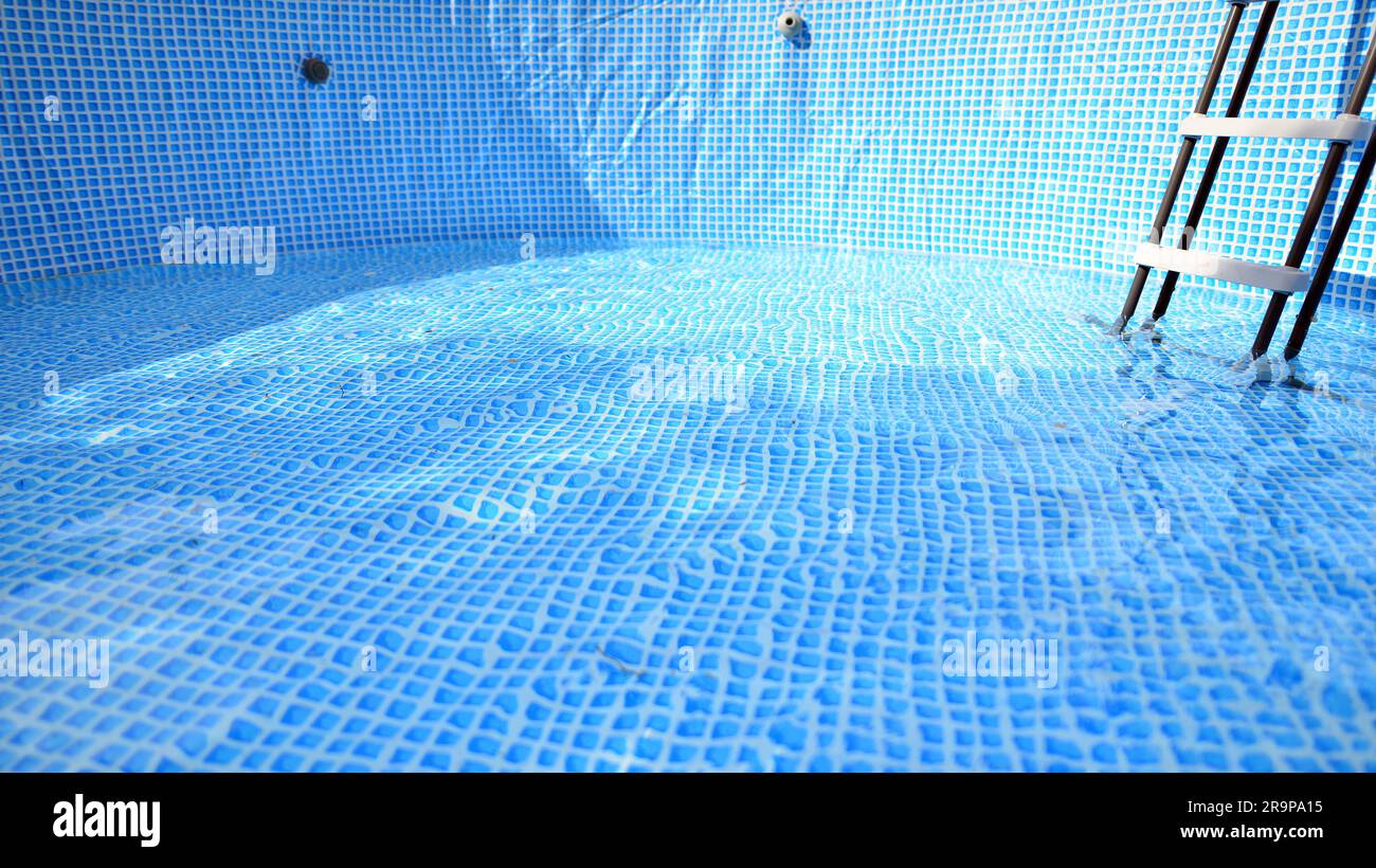 Water flowing from the hose into the pool filling. The inside of the swimming pool Stock Photo