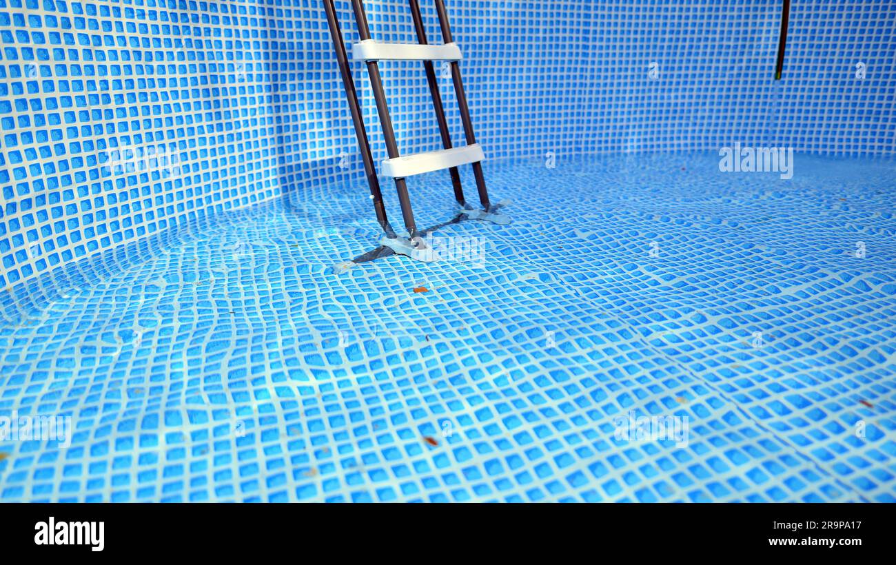Water flowing from the hose into the pool filling. The inside of the swimming pool Stock Photo