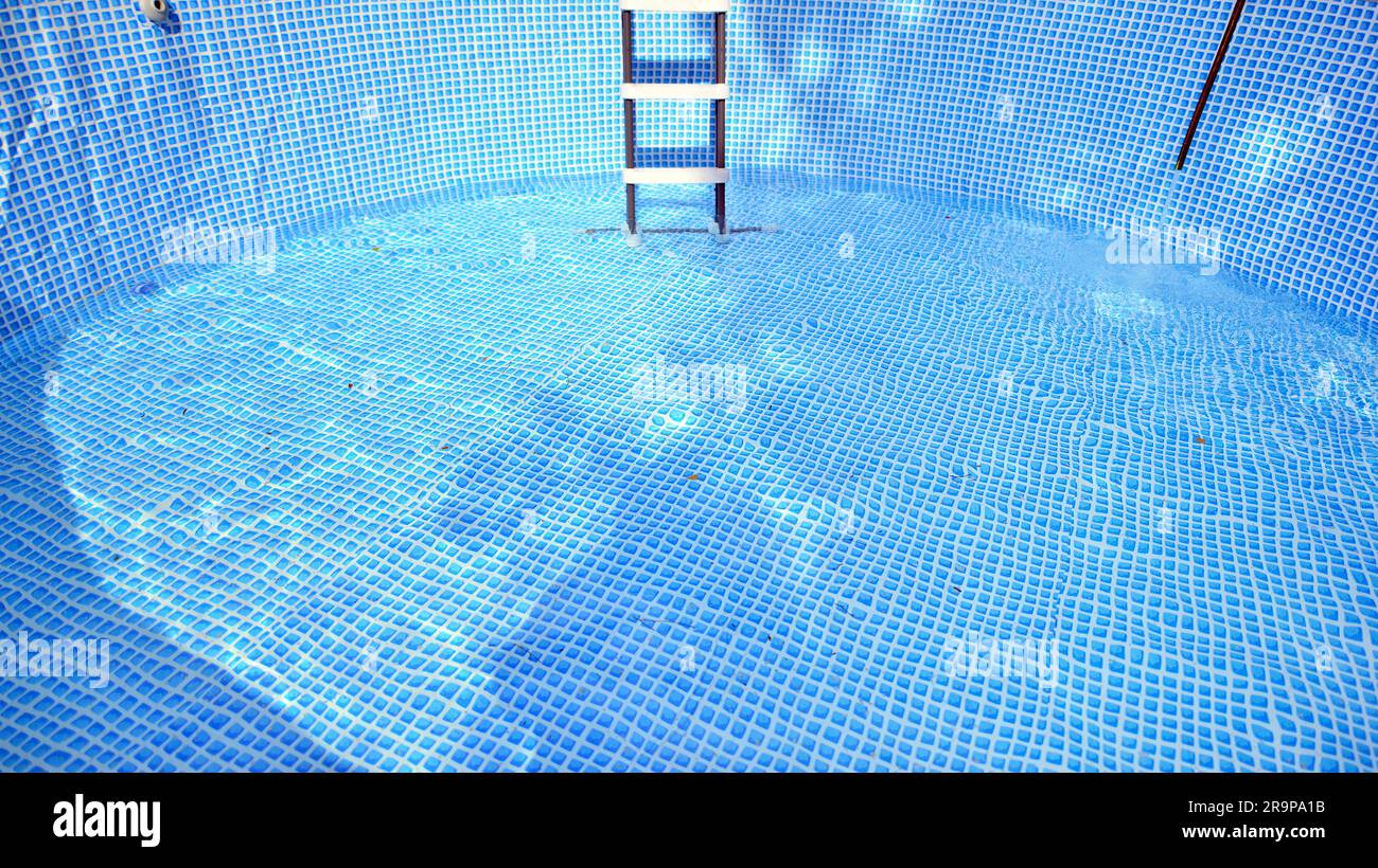 Water flowing from the hose into the pool filling. The inside of the