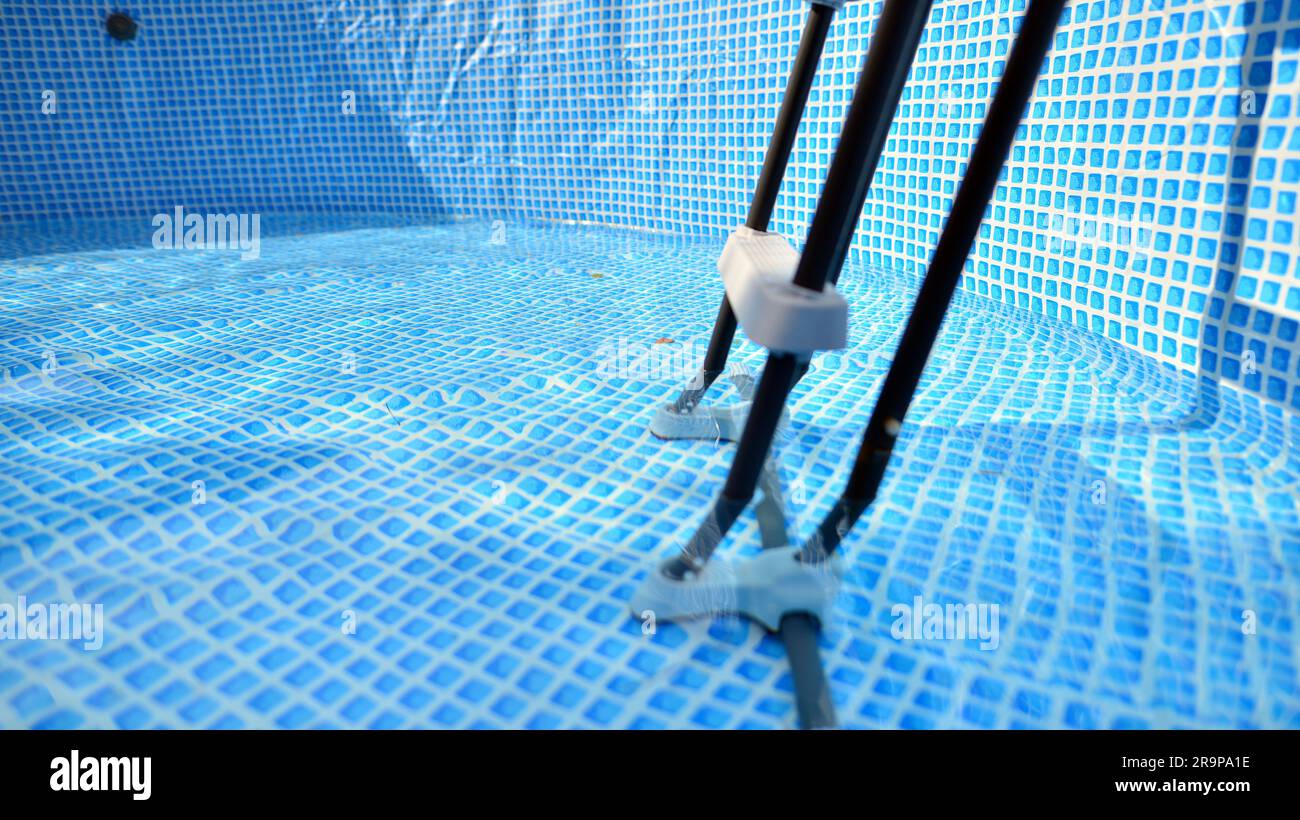 Water flowing from the hose into the pool filling. The inside of the