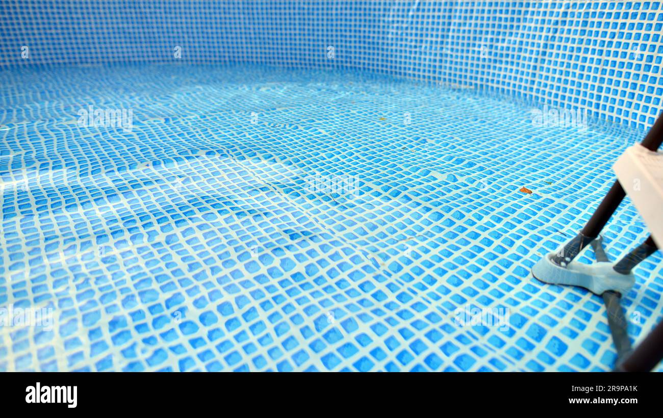 Water flowing from the hose into the pool filling. The inside of the
