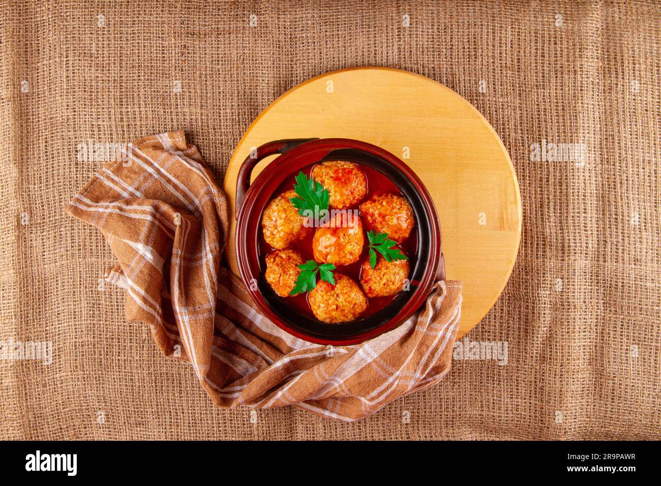 Chicken Meatballs in tomato sauce on sackcloth background with copy space Stock Photo
