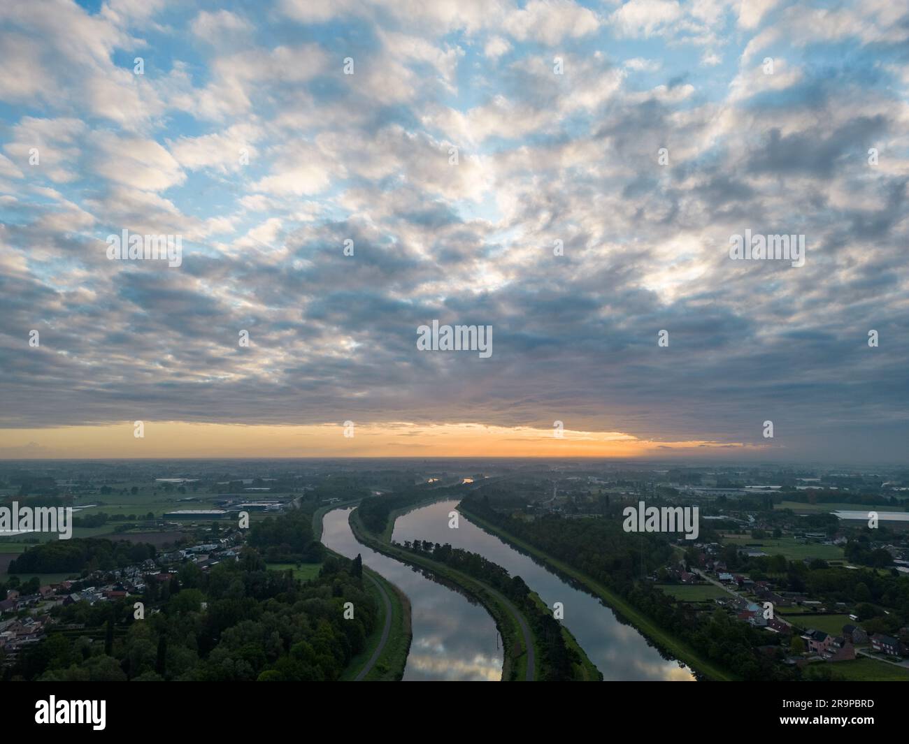 Aerial view of a colorful dramatic sunrise sky over the river Nete in Duffel, Belgium. River with water for transport, agriculture. Fields and meadows. River and forest landscape. High quality photo Stock Photo