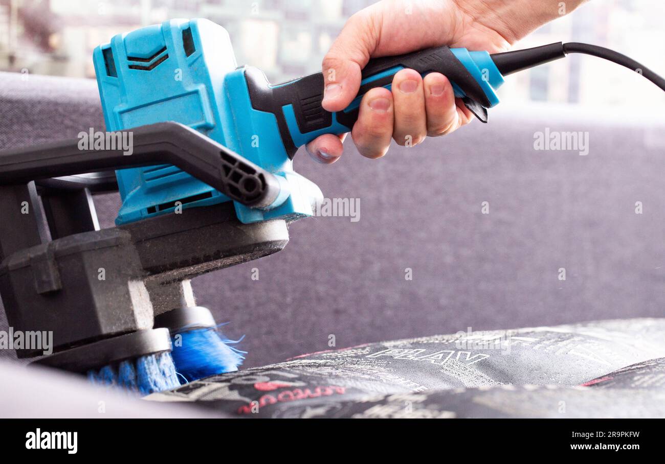 Cleaning the sofa with special equipment, an electric brush to lift the