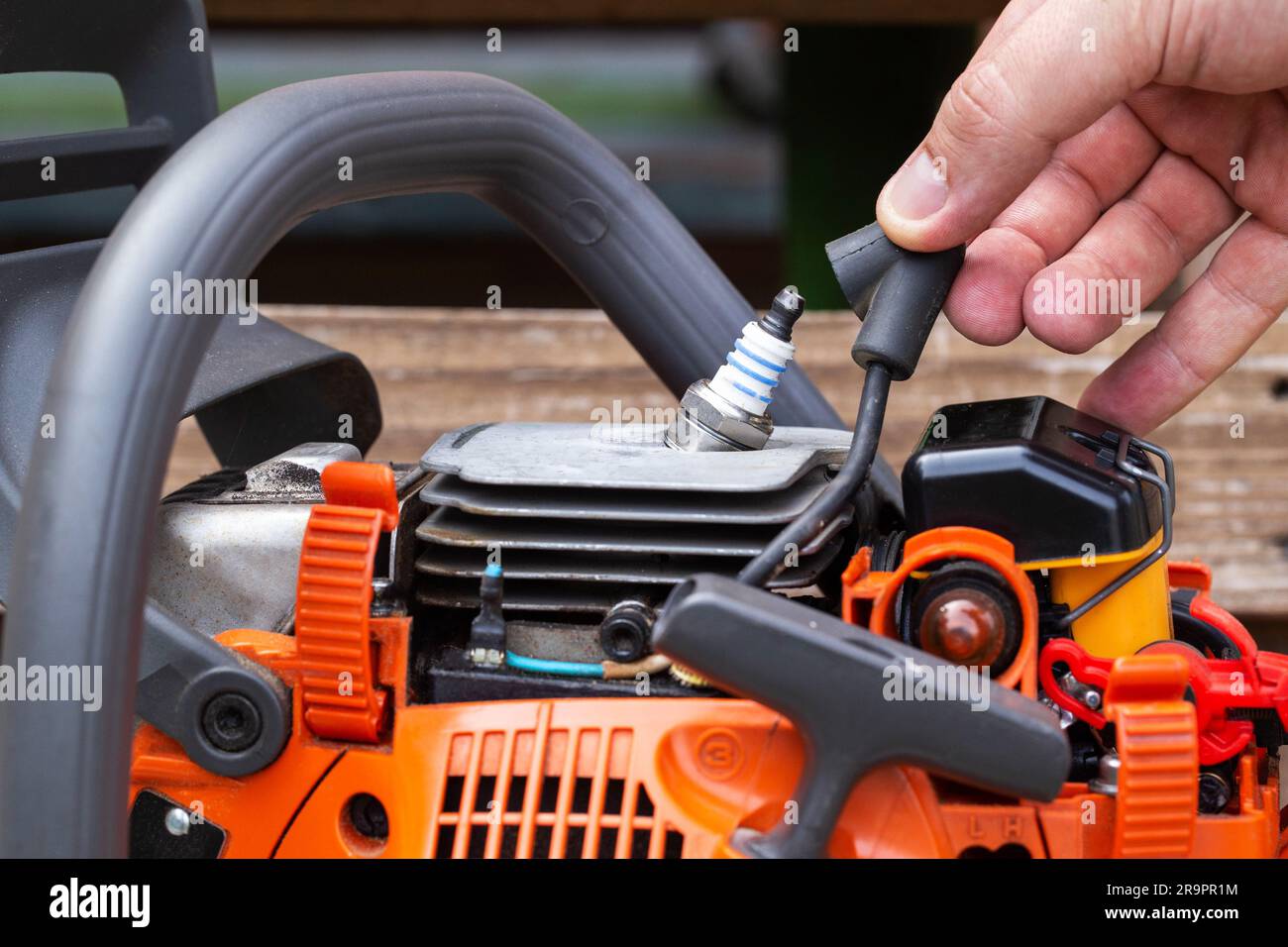 Removing the spark plug from the chainsaw cylinder. Replacing a new