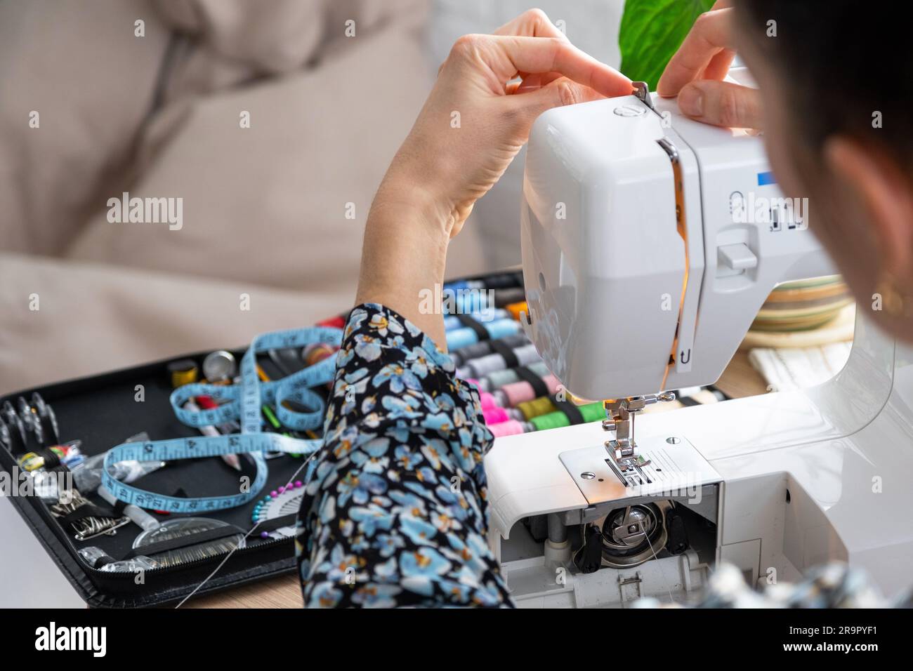 Woman hand close up sews tulle on electric sewing machine. Filling the