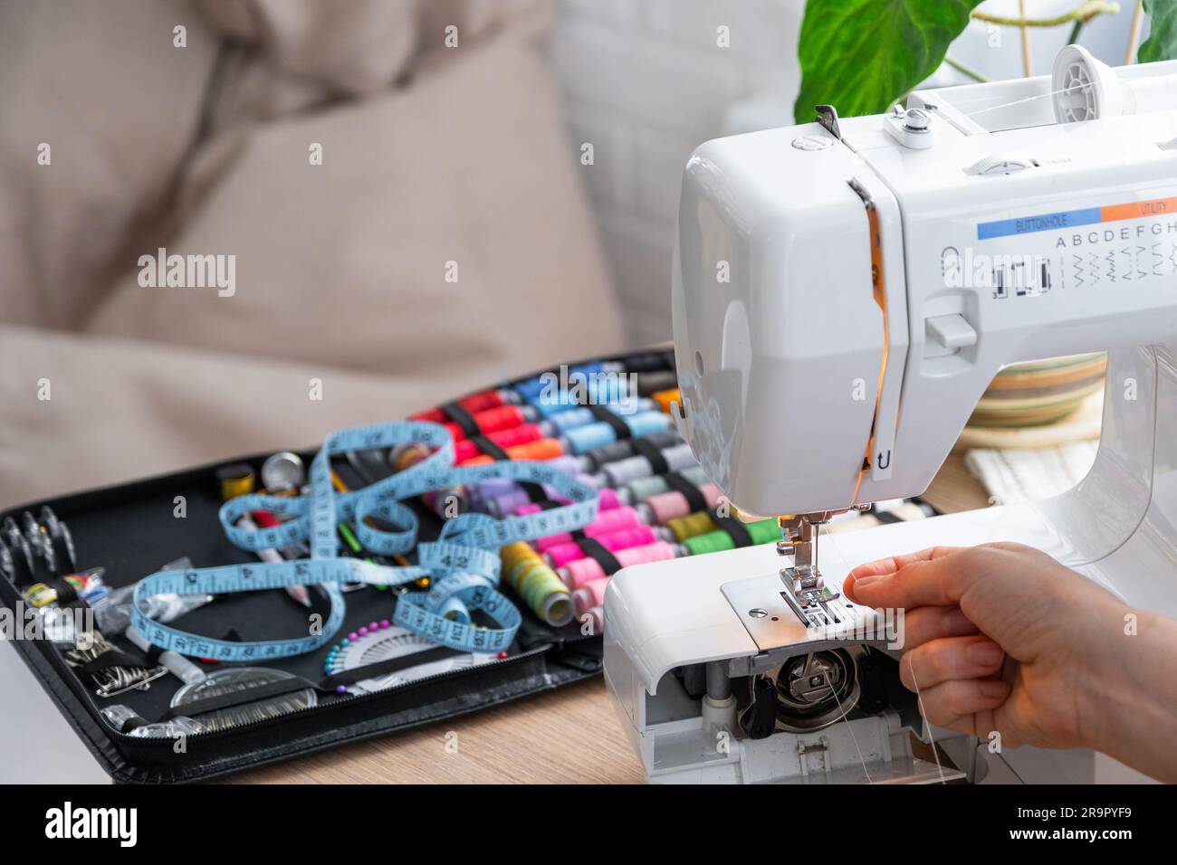 Woman hand close up sews tulle on electric sewing machine. Filling the