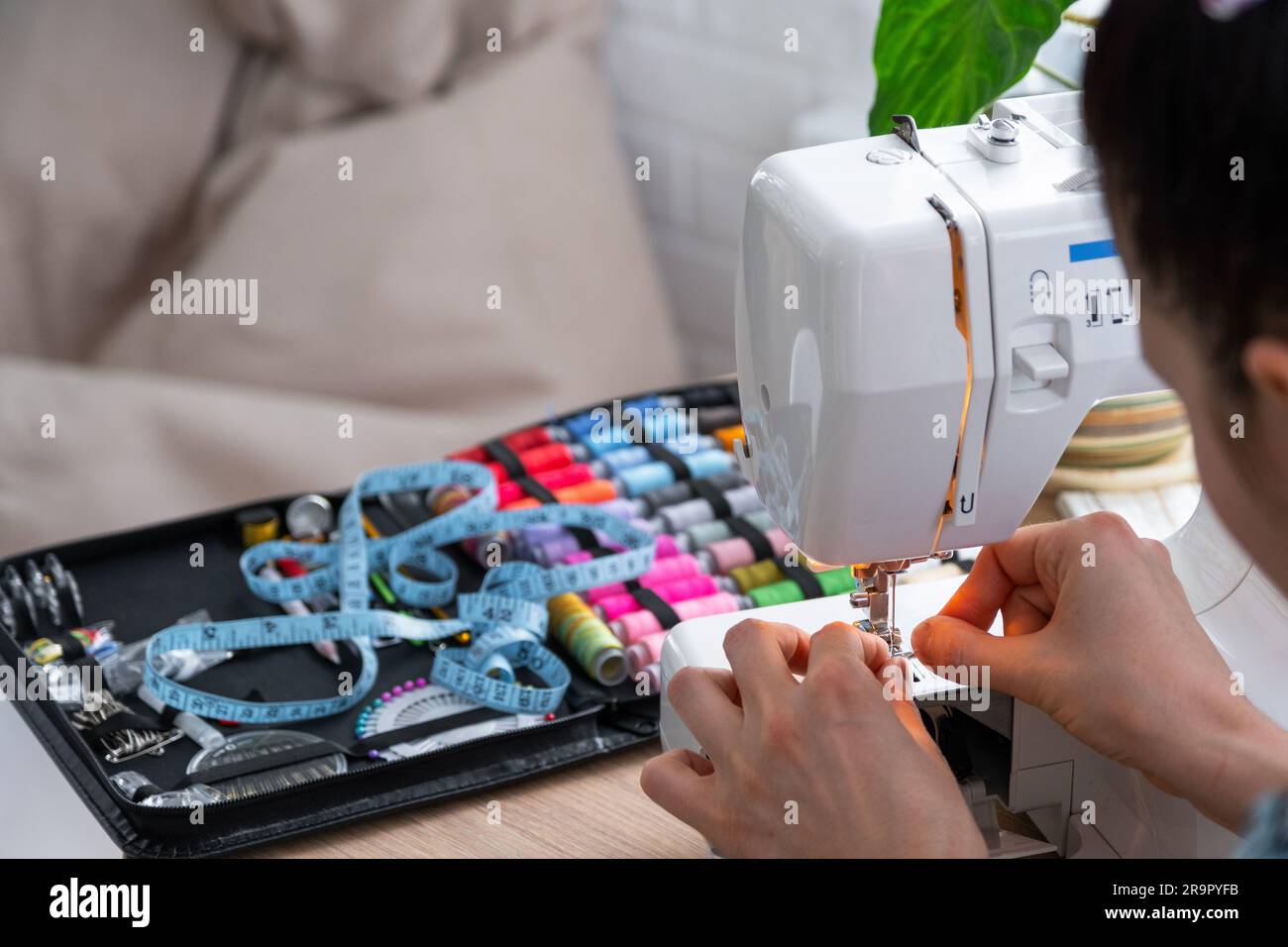 Woman hand close up sews tulle on electric sewing machine. Filling the thread into the sewing