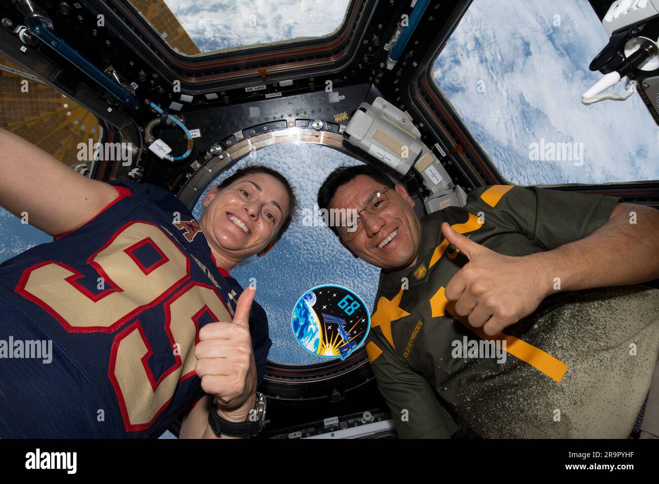 . iss068e029132 (Dec. 10, 2022) - Expedition 68 Flight Engineers Nicole Mann and Frank Rubio, both from NASA, pose with their mission's insignia inside the cupola as the International Space Station orbited 262 miles above the northern Pacific Ocean. Stock Photo