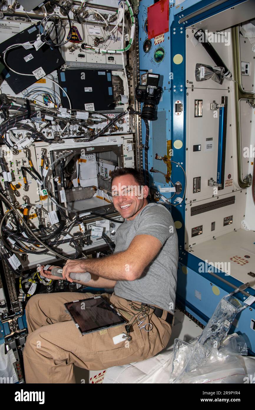 . iss068e029941 (Dec. 15, 2022) - NASA astronaut and Expedition 68 Flight Engineer Josh Cassada works in the Kibo laboratory module filling water reservoirs on the Pant Habitat for a space botany study exploring the genetic changes plants may go through when adapting to microgravity. Stock Photo