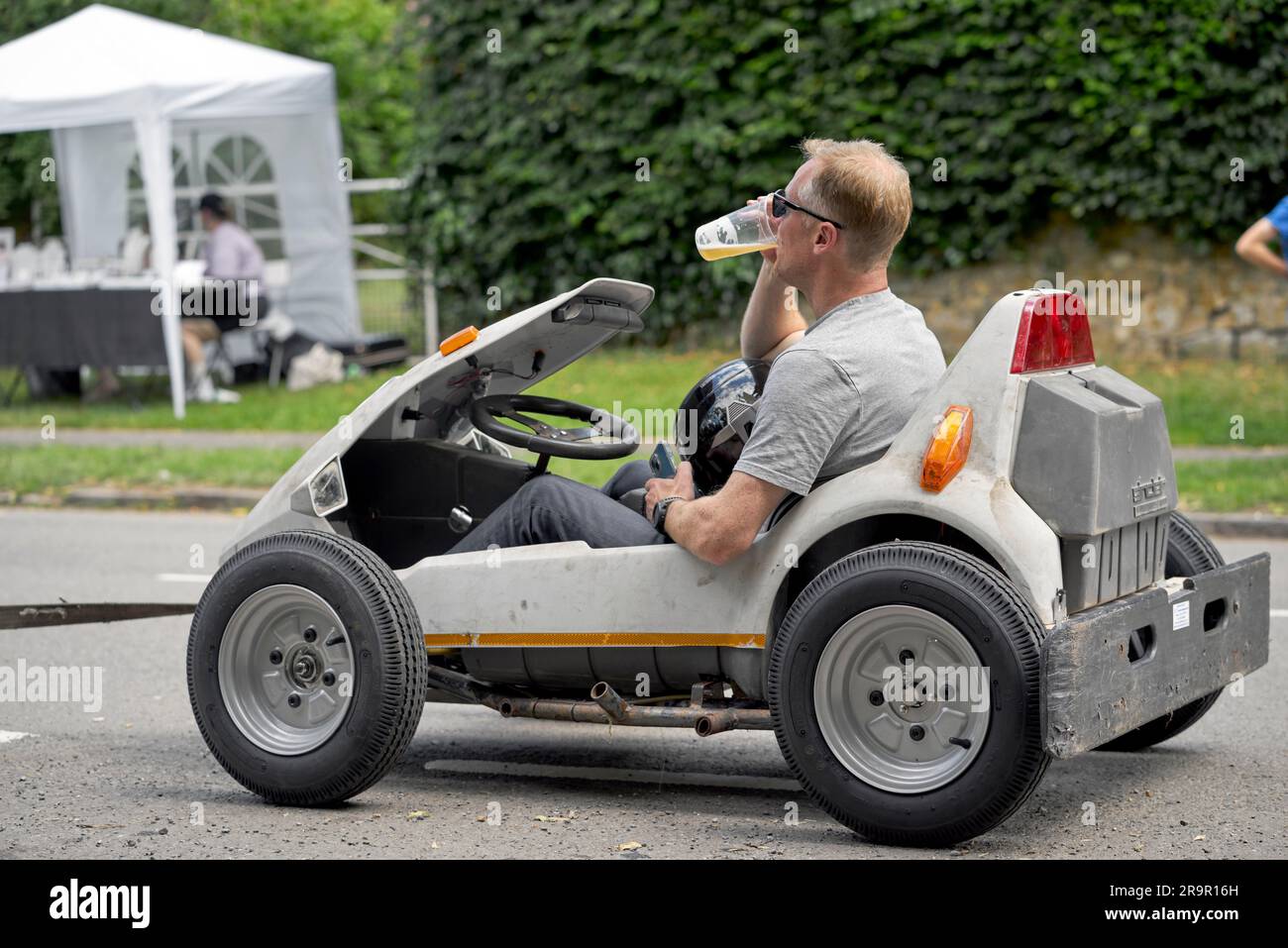 Soapbox Derby participant enjoying a refreshing beer after downhill race. England UK Stock Photo