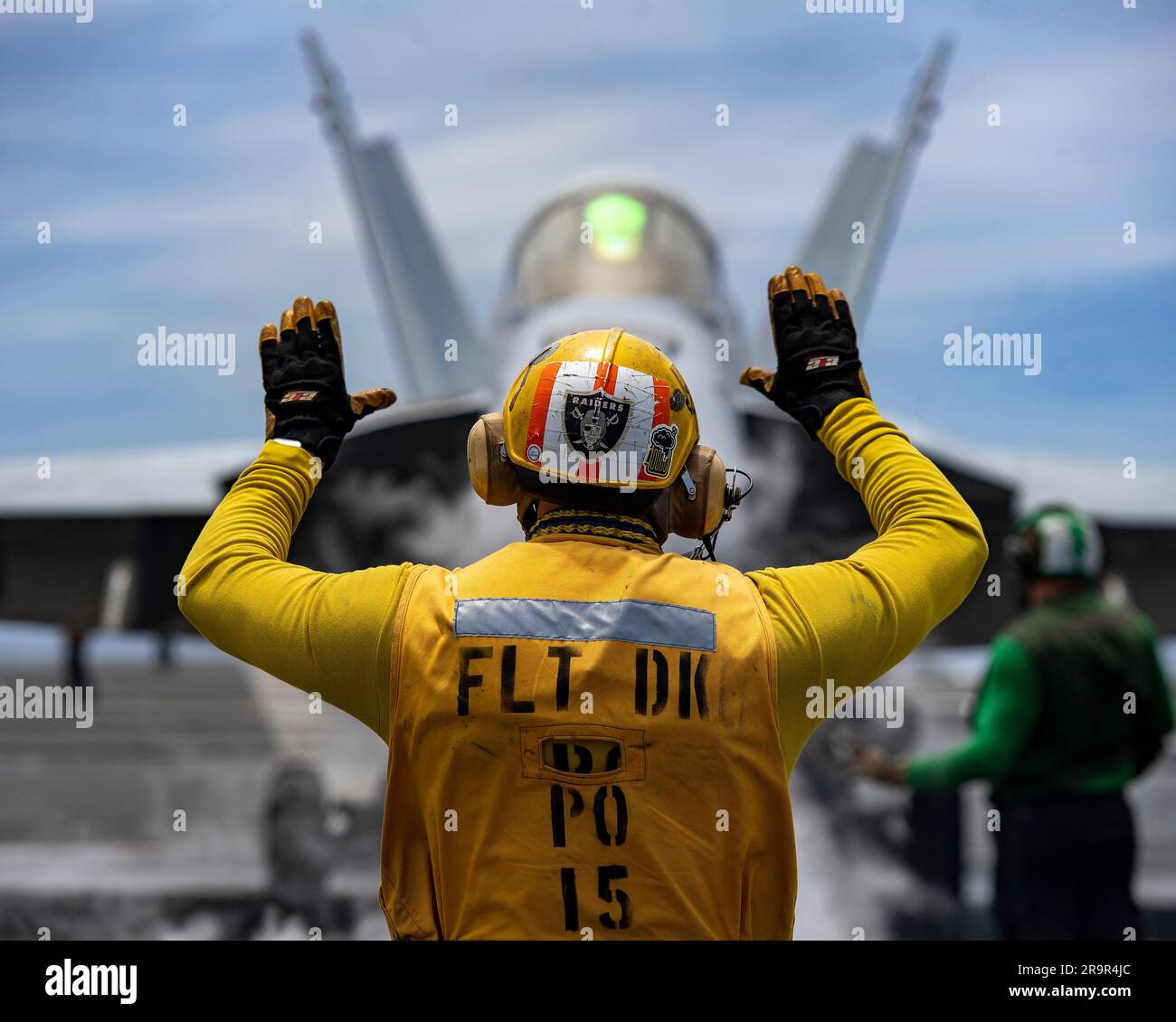 USS Nimitz, International Waters. 25 June, 2023. A U.S. Navy flight deck crew sailor directs a F/A-18F Super Hornet fighter aircraft taxi on the flight deck of the Nimitz-class aircraft carrier USS Nimitz underway conducting routine operations, June 25, 2023 on the Pacific Ocean.  Credit: MC2 Justin McTaggart/U.S Navy Photo/Alamy Live News Stock Photo