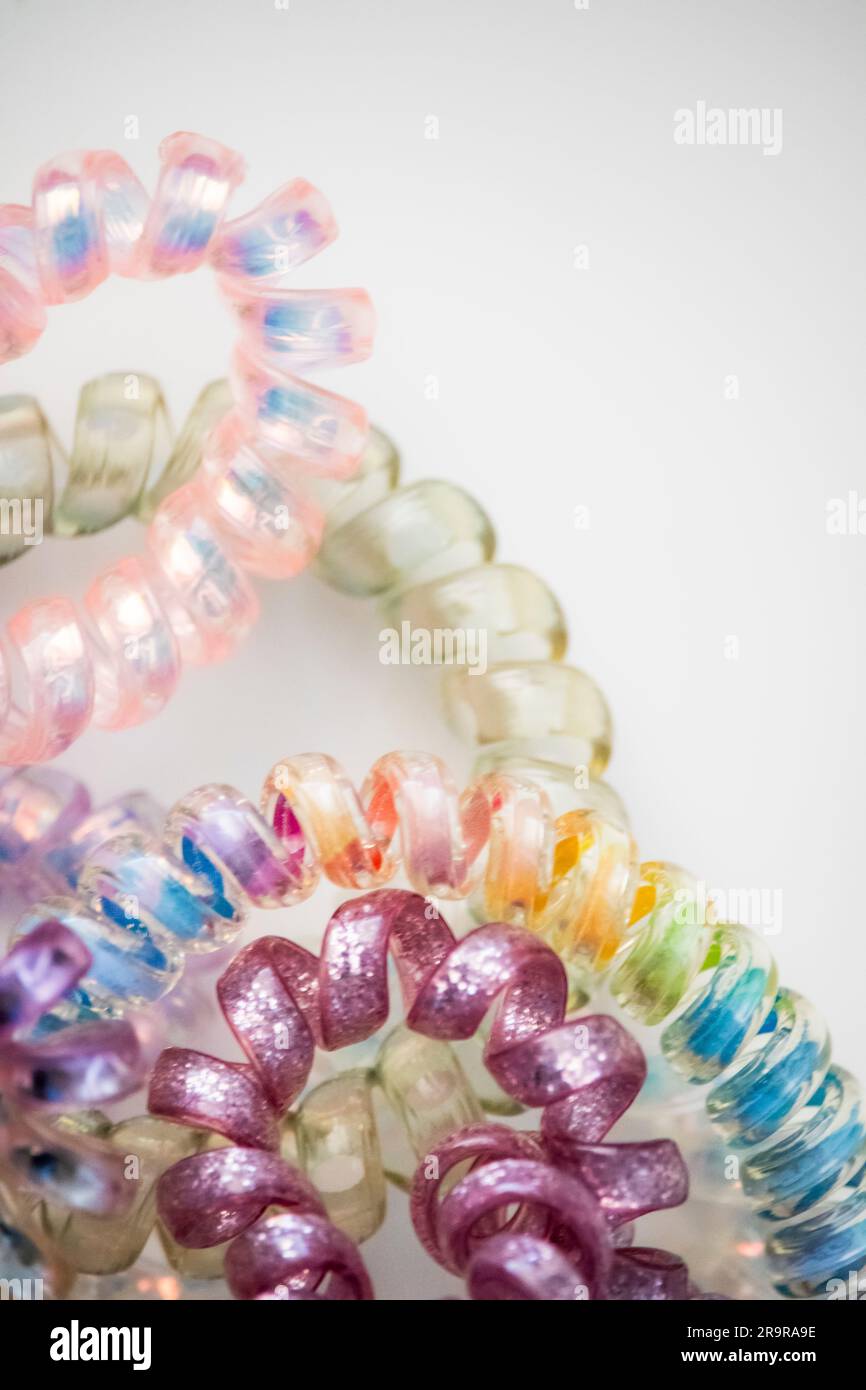 A frame of multi-colored colorful rubber bands for hair, combs and hair  clips on a black background.Copy space Stock Photo - Alamy